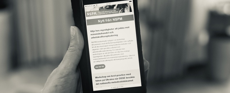 Hand som håller mobiltelefon där NSPM:s nyhetsbrev syns.
