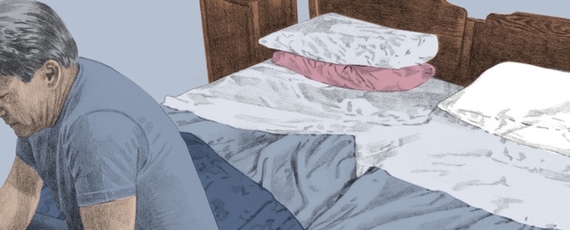 Illustration av en man som sitter på foten av en säng och tittar ner.