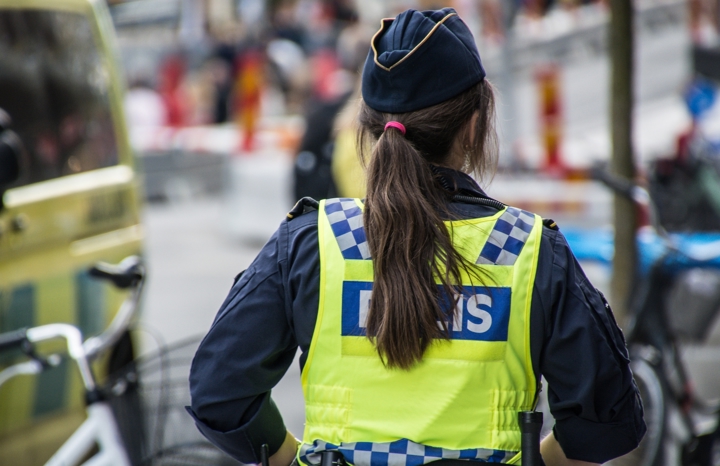 Polis i gatumiljö sedd bakifrån.